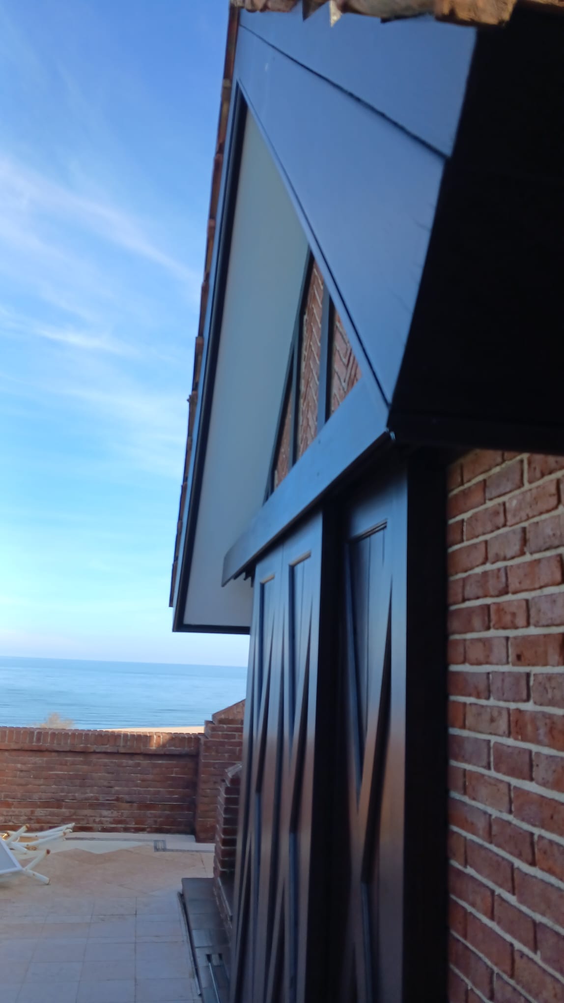 Pintura de persianas y maderas exteriores con vista al mar