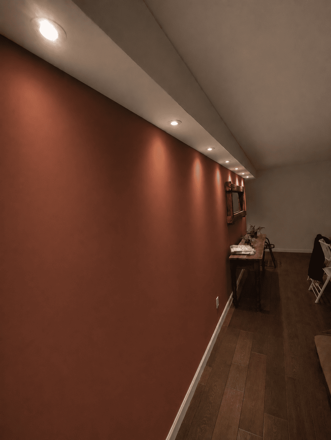 Pared de acento en color terracota con iluminación